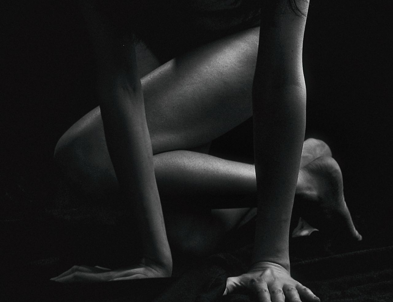 Elegant black and white portrait of a nude woman in an artistic pose.